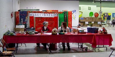 Women sitting at welcome table for Holiday Coalition.